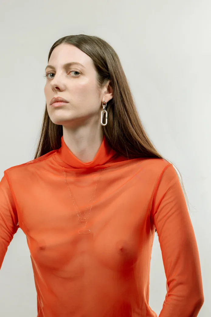 Photo d'une femme avec une boucle d'oreille et des pendentifs en argent éthique Fairmined