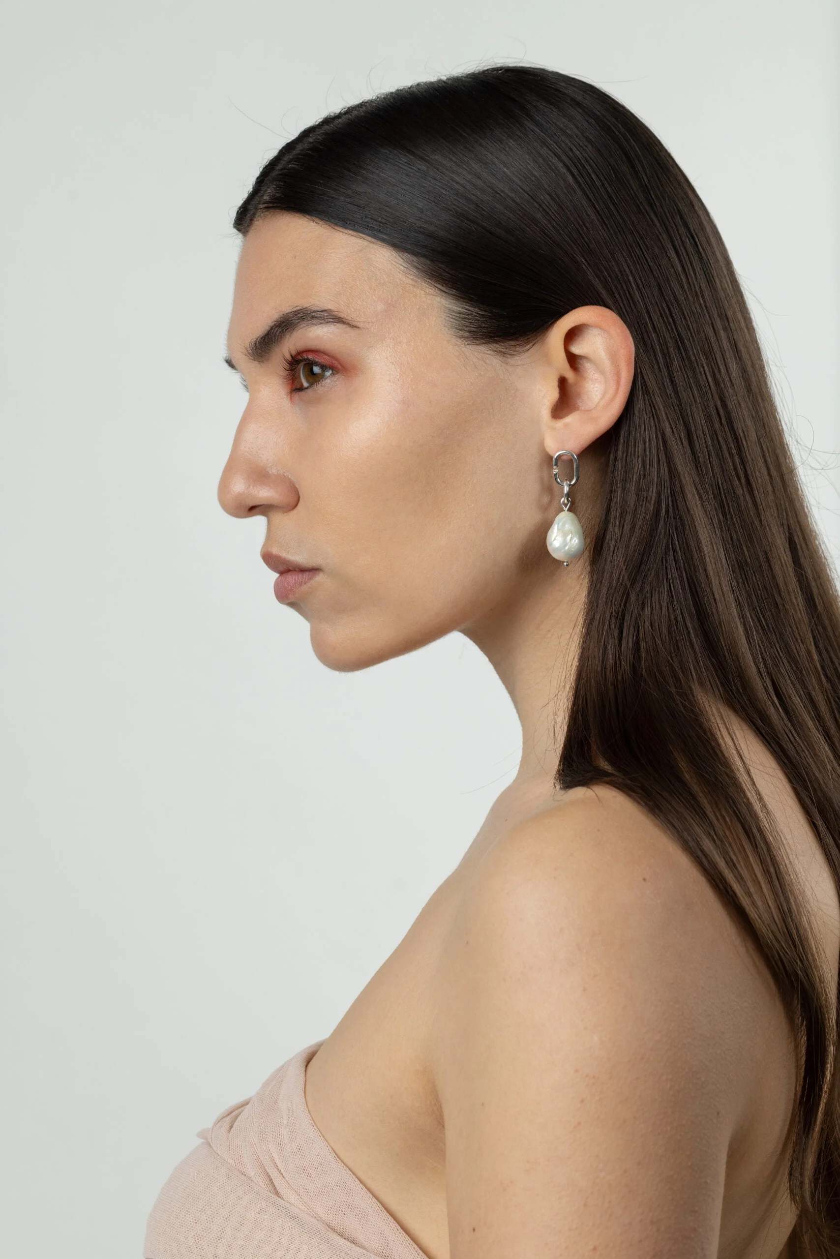 femme portant une boucle d'oreille en argent fairmined et une perle de seconde main