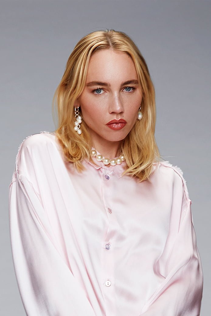 Shooting Alter Designs, édition spéciale d'une boucle d'oreille Ara cinq perles. Le modèle porte également une boucle d'oreille Ara avec une perle baroque upcyclée. Femme de face avec bijoux Mona Margaux en argent Fairmined et perles vintage