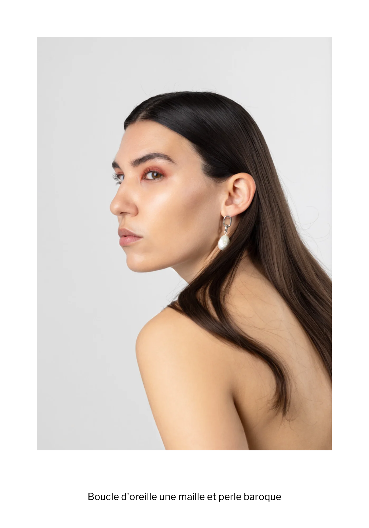Femme de profil portant une boucle d'oreille en argent fairmined et perle baroque d'occasion