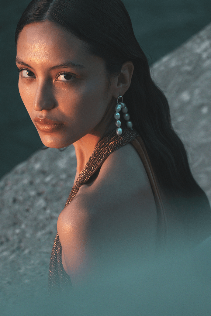 Crédit photo : Julian Succo femme avec des boucles d'oreille en perle et en argent Fairmined